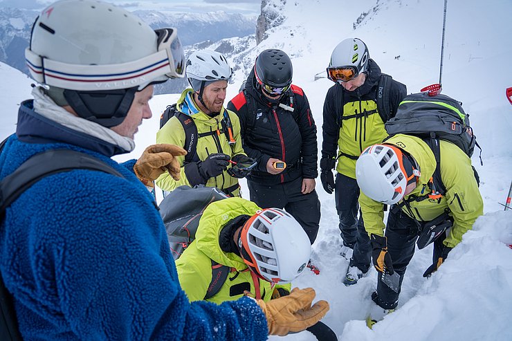 Männer im Schnee beurteilen Schneedecke