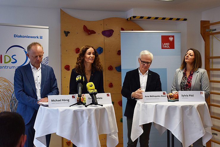 GesprächsteilnehmerInnen stehen an zwei Stehtischen vor Rollups