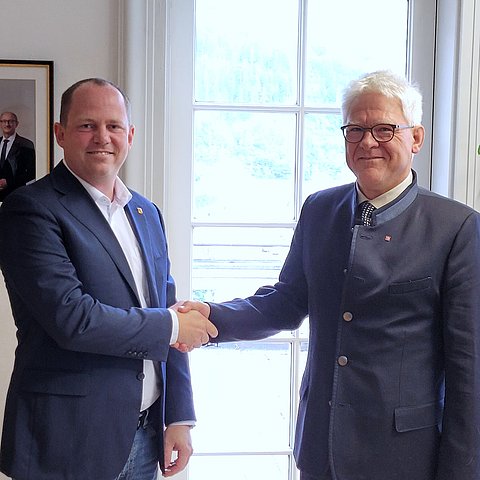 Zwei Menschen schütteln sich die Hände.