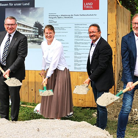 Spatenstich mit Schaufeln bei kleinen Hügel mit Erde