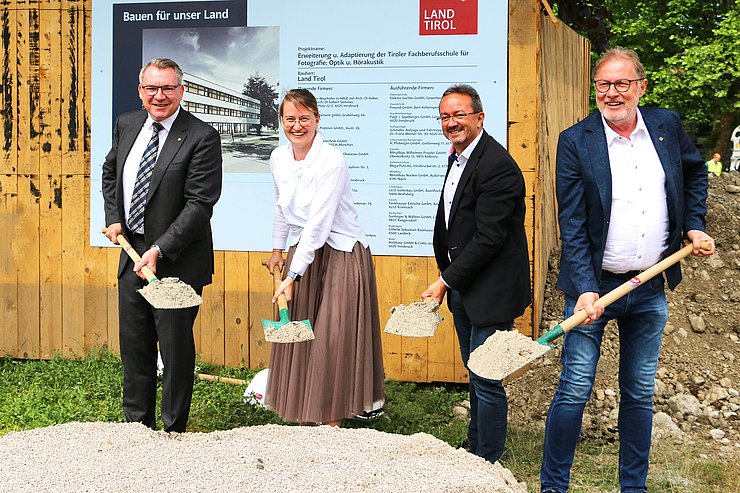 Spatenstich mit Schaufeln bei kleinen Hügel mit Erde