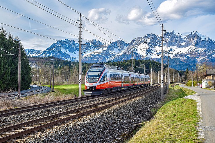 © ÖBB Eine ÖBB-Zuggarnitur fährt auf Gleisen, im Hintergrund sieht man Berge.