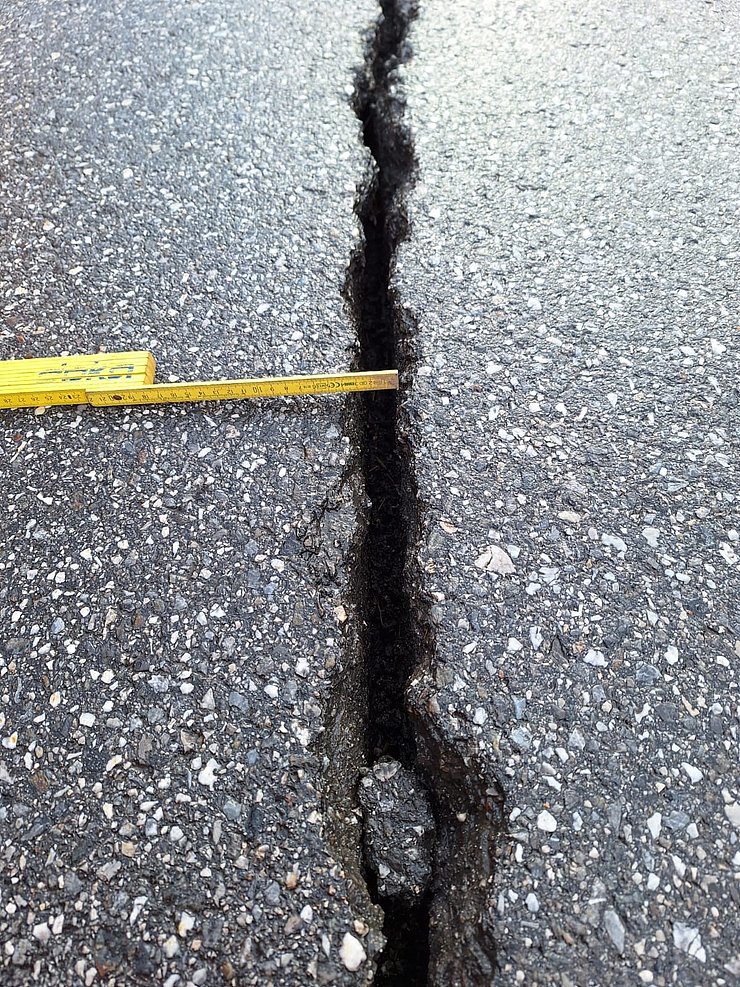 © Land Tirol Riss in Asphalt; Zollstock wird an Riss gehalten