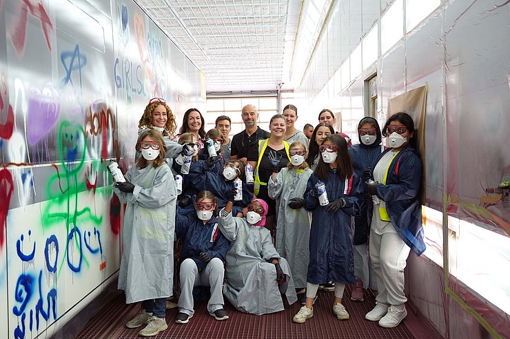 Gruppenfoto von Landesrätin Pawlata und einer Volksschulklasse neben einem bemalten Bus.