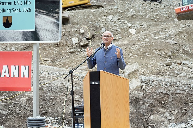 Person am Rednerpult im Freien