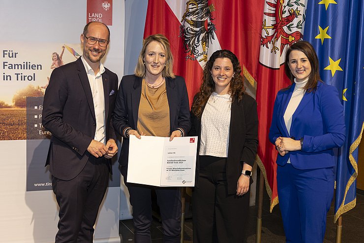 vier Personen mit Urkunde