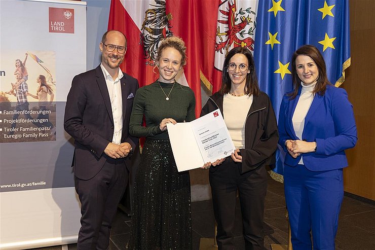 vier Personen mit Urkunde