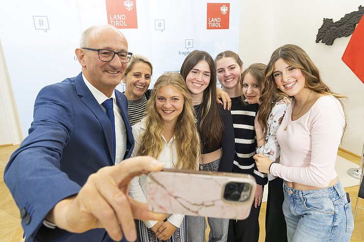 © Land Tirol/Die Fotografen Der Landeshauptmann macht ein Selfie mit einer Schülerinnengruppe.