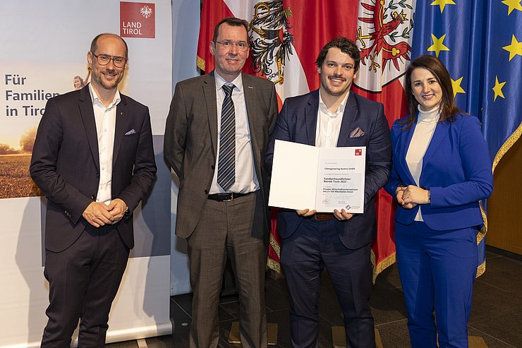 vier Personen mit Urkunde