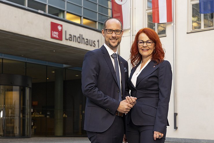 Landesrat Mario Gerber und Landesrätin Cornelia Hagele stehen vor Gebäude