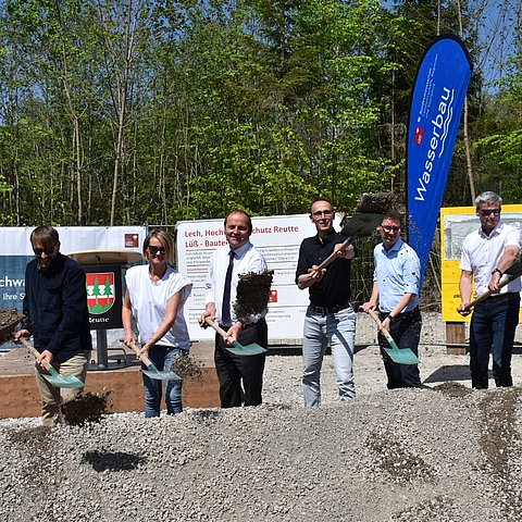 Die 8 Personen nebeneinander stehend beim Spatenstich