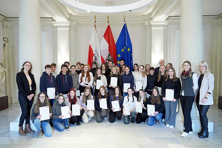 © Land Tirol/Neuner Gruppenfoto in einer prunkvollen Säulenhalle.