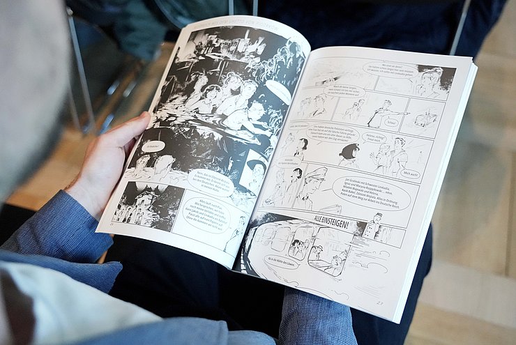 © Land Tirol/Neuner Ein Mann blättert in einem Comicroman.