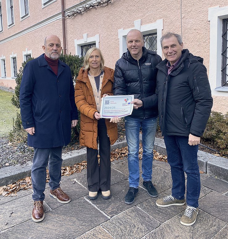 © Euregio Personen halten Aufkleber, stehen vor Schule