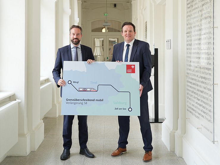 Zwei Männer mit einer Tafeln "Verlängerung S8"