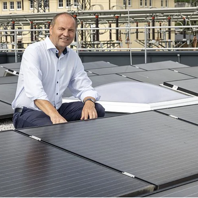 Landeshauptmannstellvertreter Josef Geisler sitzt zwischen PV-Anlagen.