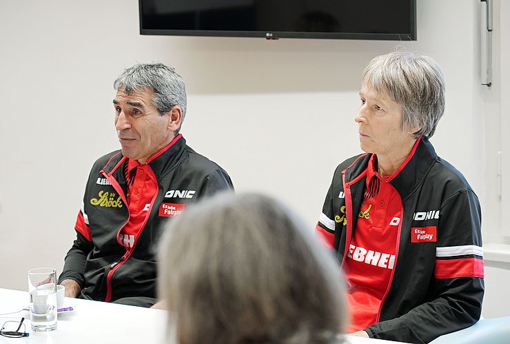 Wiederum ein neuer Blickwinkel: Nahaufnahme eines Mannes und einer Frau, die beide einen Trainingsanzug tragen. 