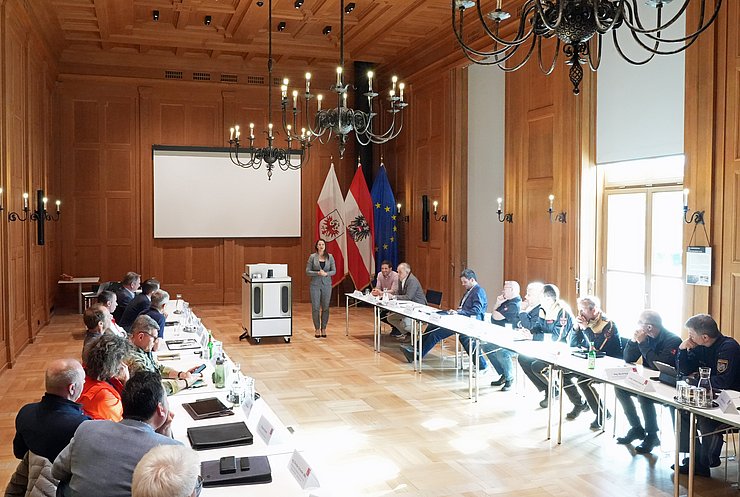 Raum mit Personen an Tisch sitzend