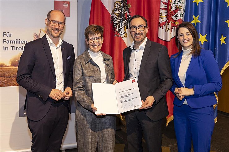 vier Personen mit Urkunde