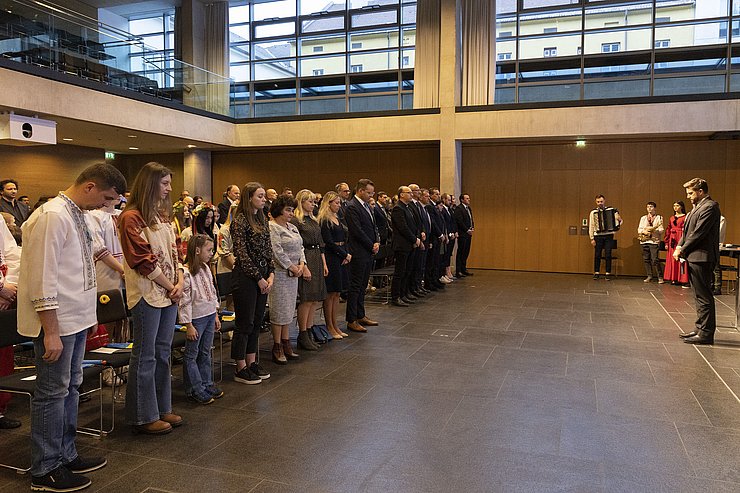 Menschen halten eine Gedenkminute