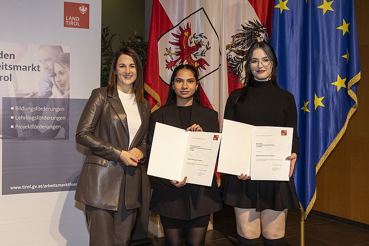 Landesrätin Mair mit zwei ausgezeichneten Lehrlingen.