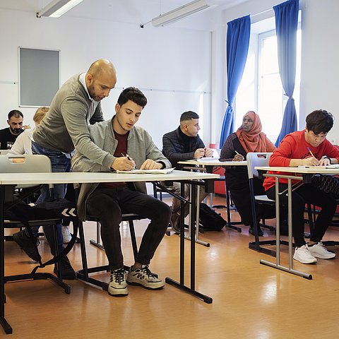 Eine Klasse mit Flüchtlingen lernt Deutsch.