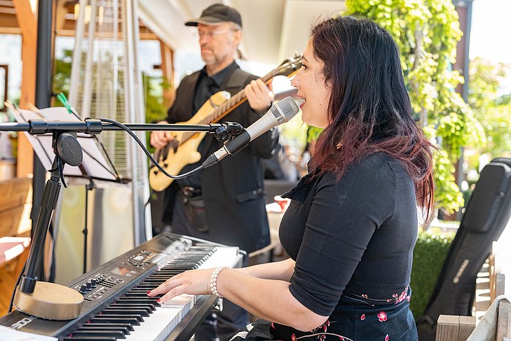 Sängerin sitzt am Klavier