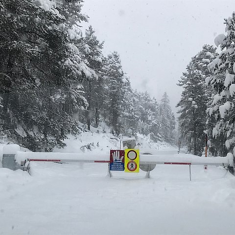 Aufnahme der verschneiten Straße mit heruntergelassenen Schranken