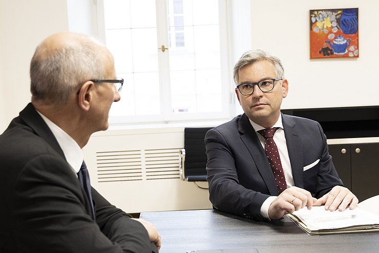 Finanzminister Brunner von vorne spricht mit LH Mattle, der von hinten zu sehen ist