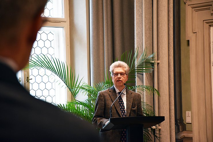 Mann steht vor Rednerpult und spricht