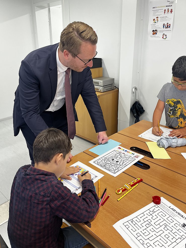 Ein Mann spricht mit zwei Schülern.