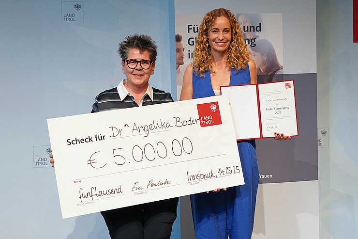 Personen stehen nebeneinander, halten Scheck und Urkunde