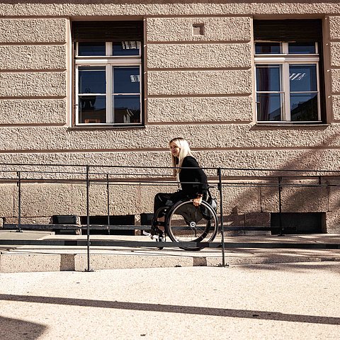 Frau im Rollstuhl auf Rampe