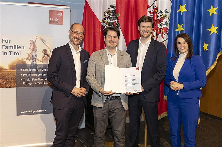 vier Personen mit Urkunde