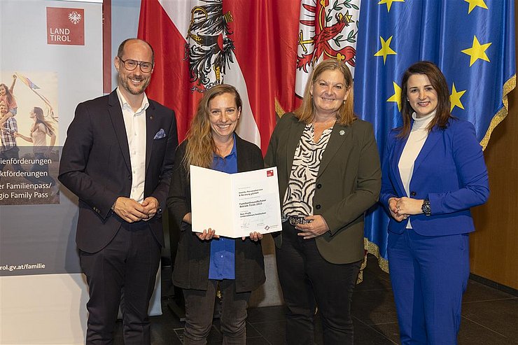 vier Personen mit Urkunde