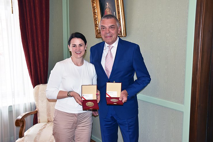 © Land Tirol/Pölzl Mair und Logar stehen nebeneinander, lachen und halten ihre Auszeichnungen in die Kamera