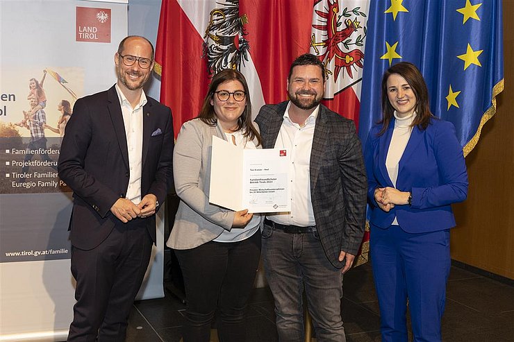 vier Personen mit Urkunde