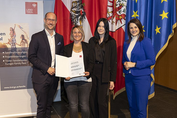 vier Personen mit Urkunde