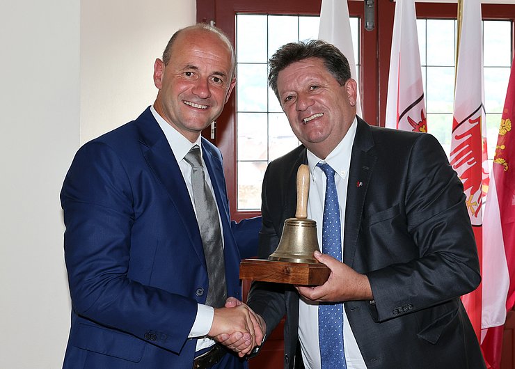 © Euregio/Matteo Rensi Schöpf und Gianmoena halten die Glocke des Euregio-Rates der Gemeinden