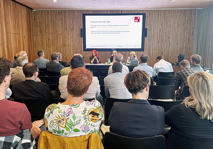 Drei Frauen sitzen an einem Tisch und halten einen Vortrag.