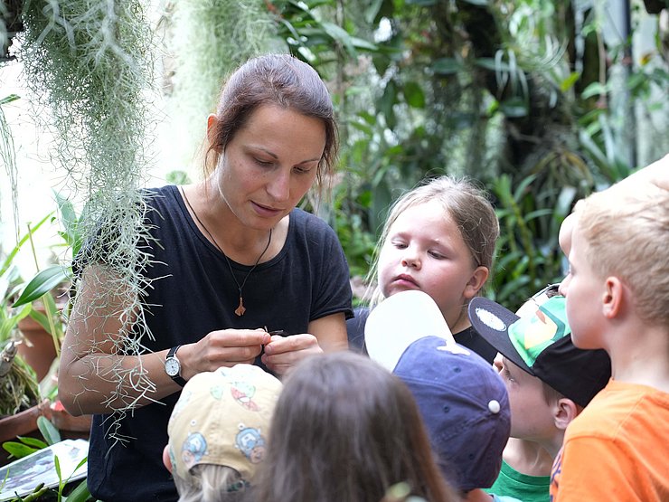Erwachsene mit mehreren Kindern umgeben von Pflanzen