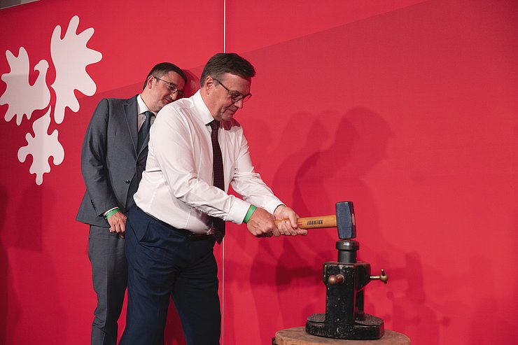 © Land Tirol/Sedlak LH Platter prägt eine Euregio-Gemeindemünze