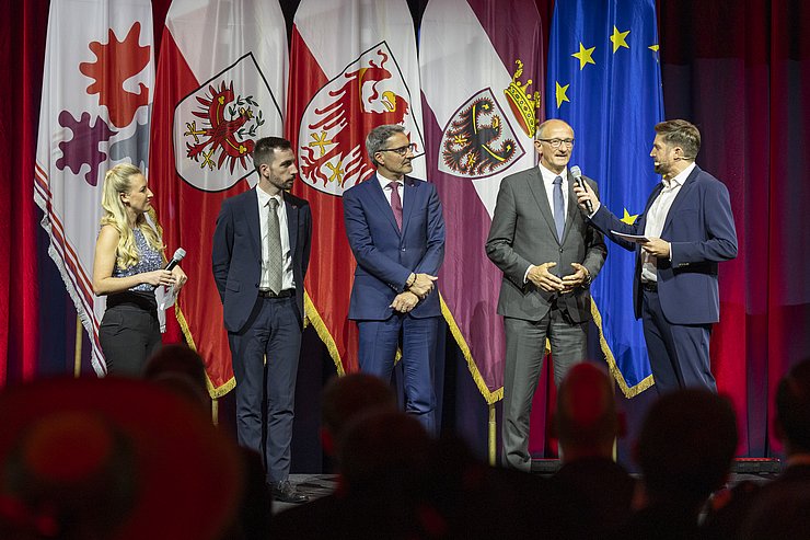 Fünf Menschen stehen auf einer Bühne.