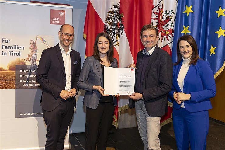 vier Personen mit Urkunde