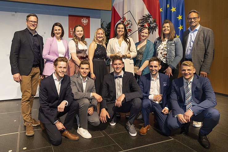 © Land Tirol/Die Fotografen Die Lehrlinge des Jahres 2022 (zwei waren entschuldigt) mit Arbeits- und Jugendlandesrätin Astrid Mair (2. v. li. hi.), Klaus Rainer (Vizepräsident Arbeiterkammer Tirol, li. hi.) und Christoph Walser (Präsident Wirtschaftskammer Tirol, re. hi.).