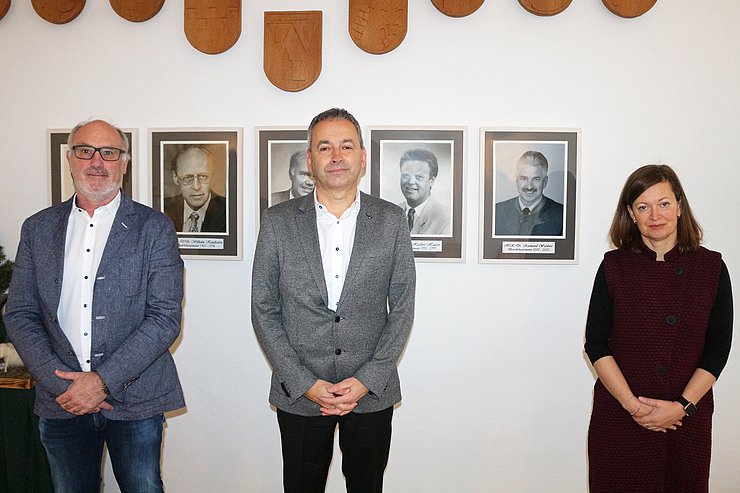 Huter, Bartl und Loidhold stehen vor einer Fotowand