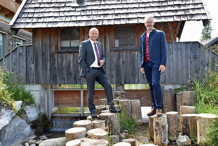 Geisler und Wackerle stehen auf Baumpflöcken im Wildsee