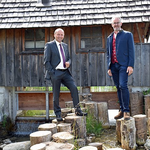 Geisler und Wackerle stehen auf Baumpflöcken im Wildsee