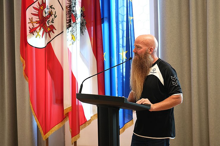 © Land Tirol/Pölzl Höllbacher redend an Podium