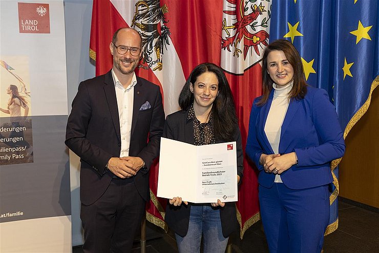 drei Personen mit Urkunde